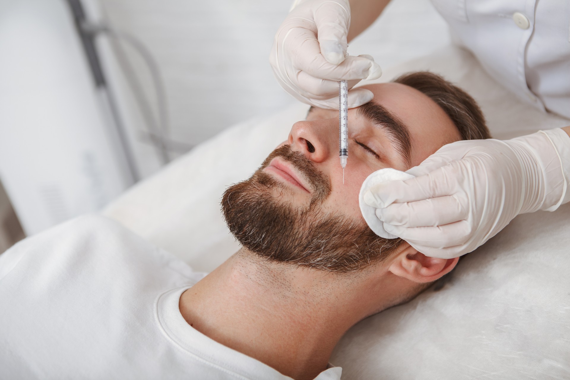 Handsome man getting facial skincare treatment at salon